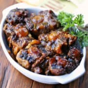 Slow cooker oxtail is served in a white dish.