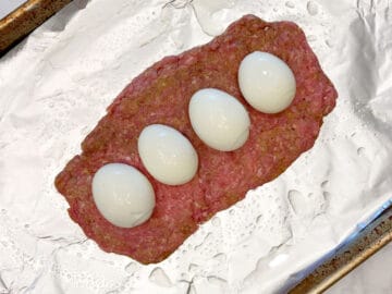 Topping the bottom beef layer with hard-boiled eggs.