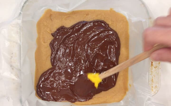 Spreading the melted chocolate on the hardened bottom layer.