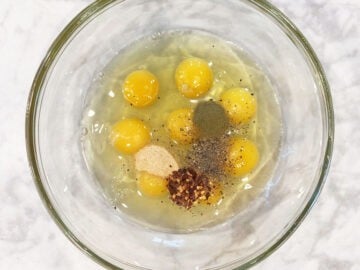 Mixing eggs and spices in a bowl.