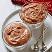 Cottage cheese chocolate mousse is served in dessert glasses with dessert spoons.