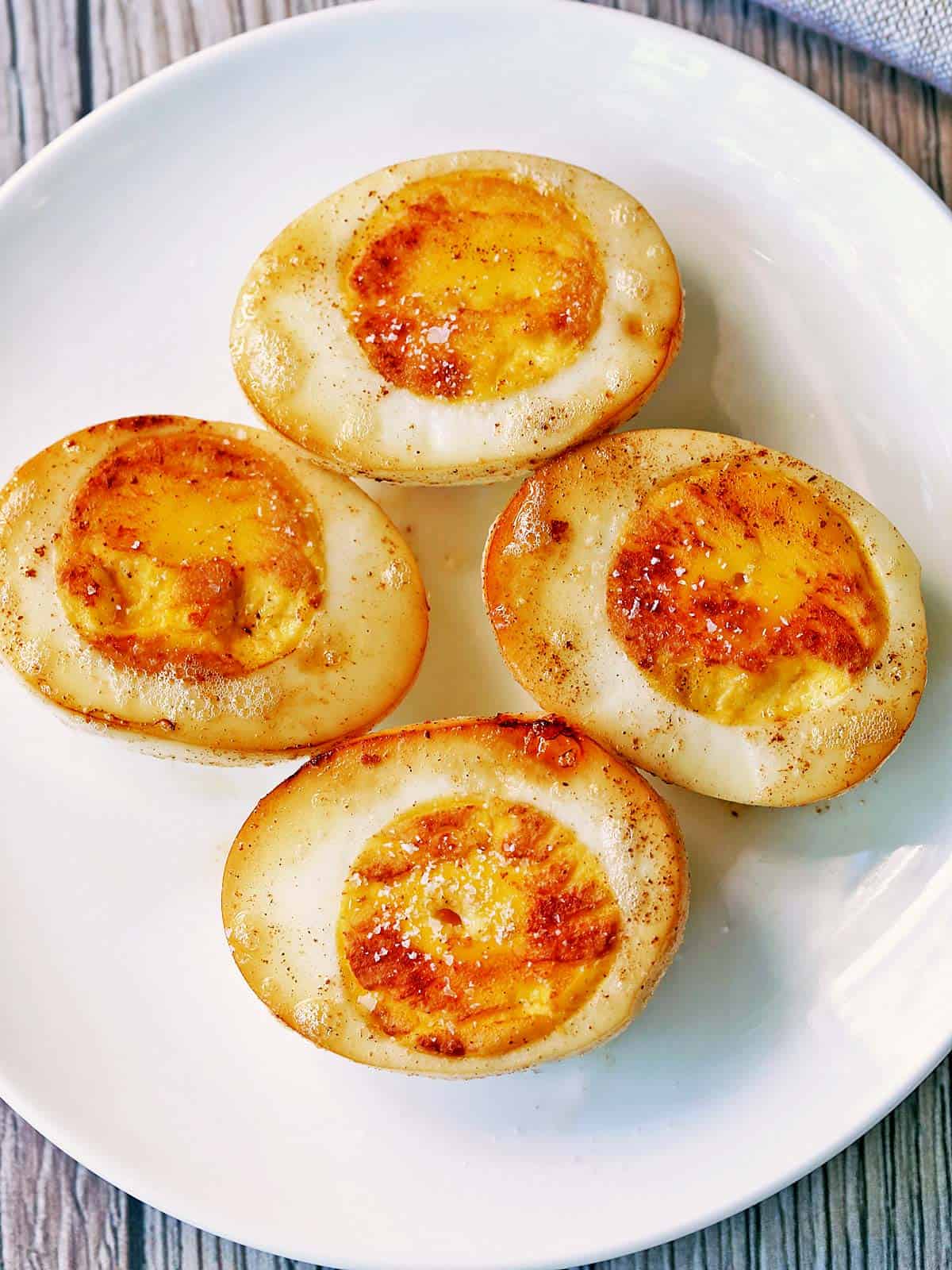 Fried boiled eggs are served on a white plate.