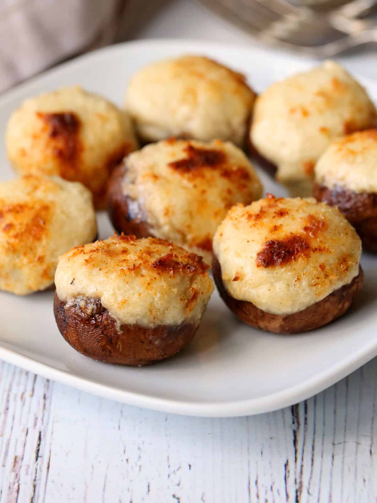 Keto stuffed mushrooms are served on a white plate.