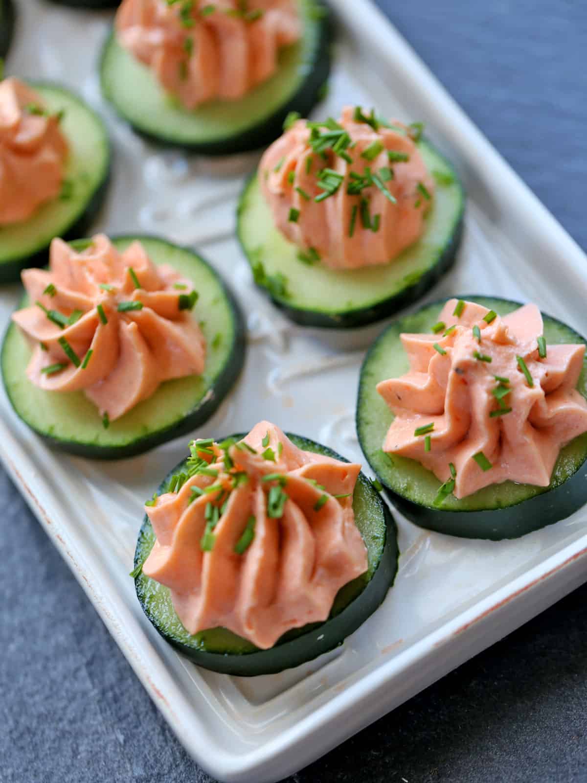 Salmon mousse is served on cucumber slices.