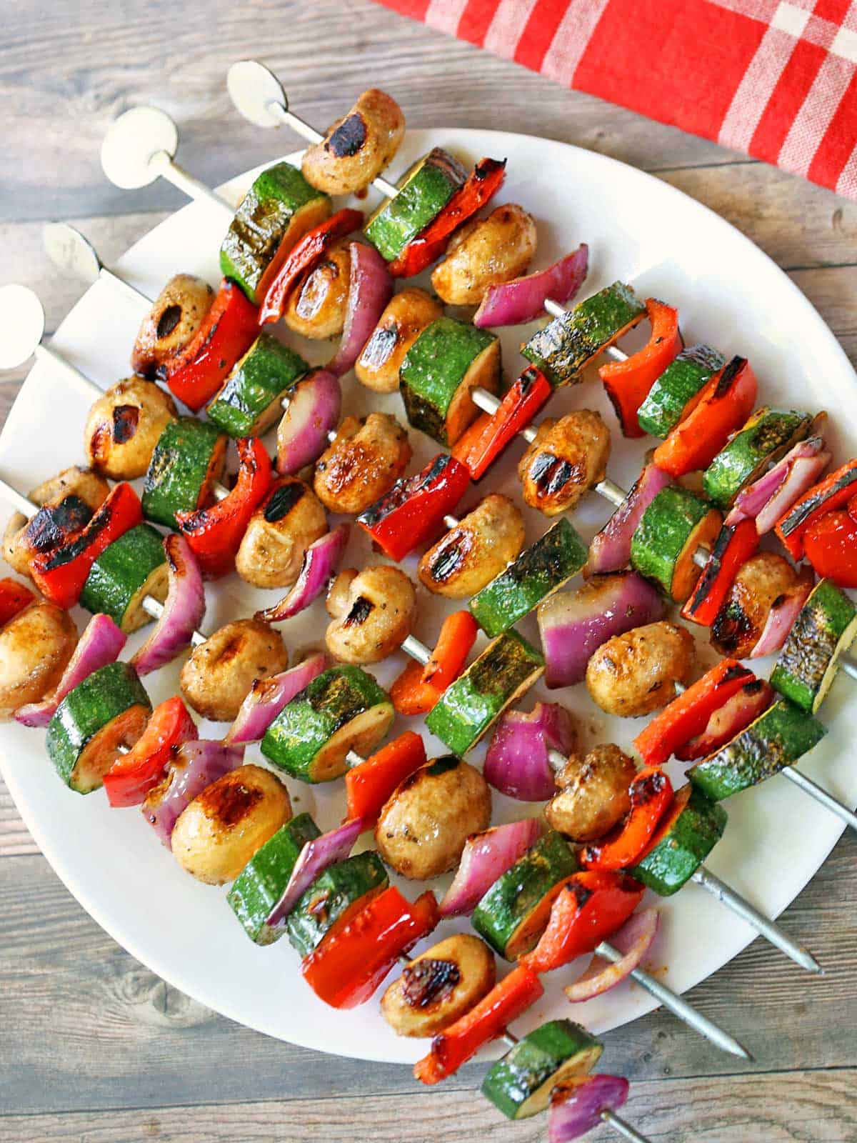 Veggie kabobs are served on a white plate.