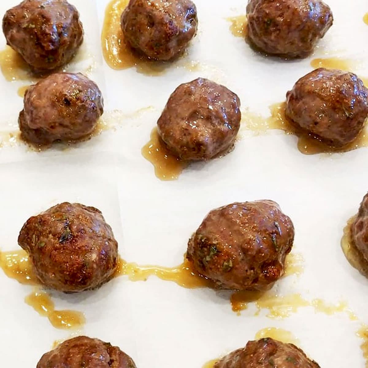 The meatballs are ready on the baking sheet.