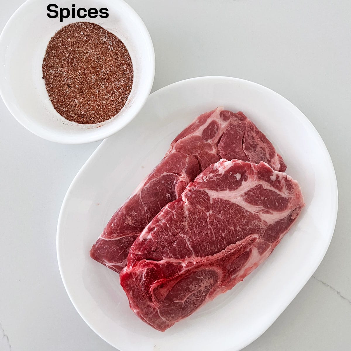 The ingredients needed to cook pork steaks.