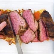 Slicing a roasted tri-tip on a cutting board.