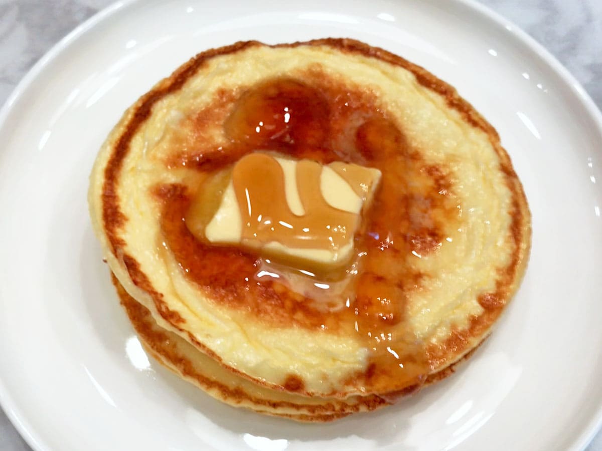 Cream cheese pancakes are topped with butter and syrup.