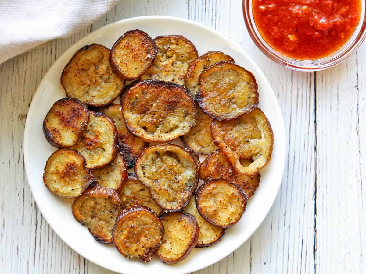 Eggplant chips are served with salsa.
