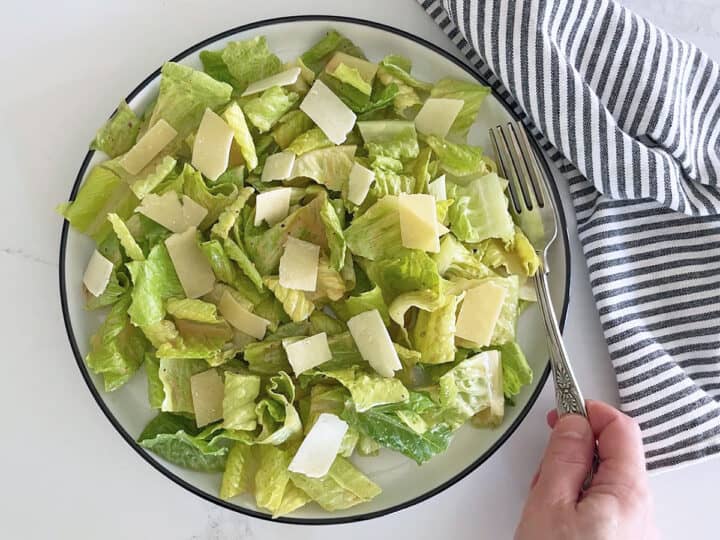 The salad is served with a napkin and a fork.