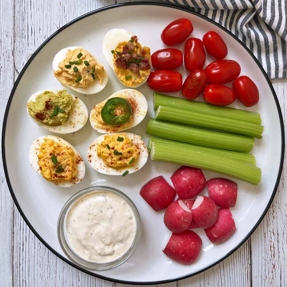 Deviled eggs are served with fresh-cut veggies and a blue cheese dip.