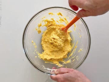 Mixing the yolks with the condiments.