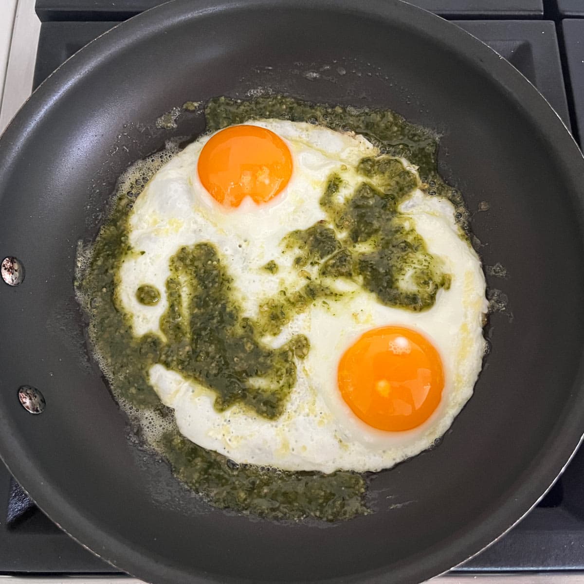 Pesto eggs are ready in the skillet.