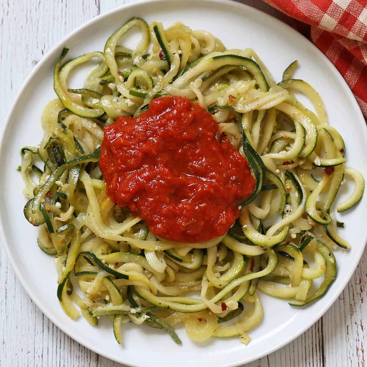 Zucchini noodles are topped with marinara sauce.
