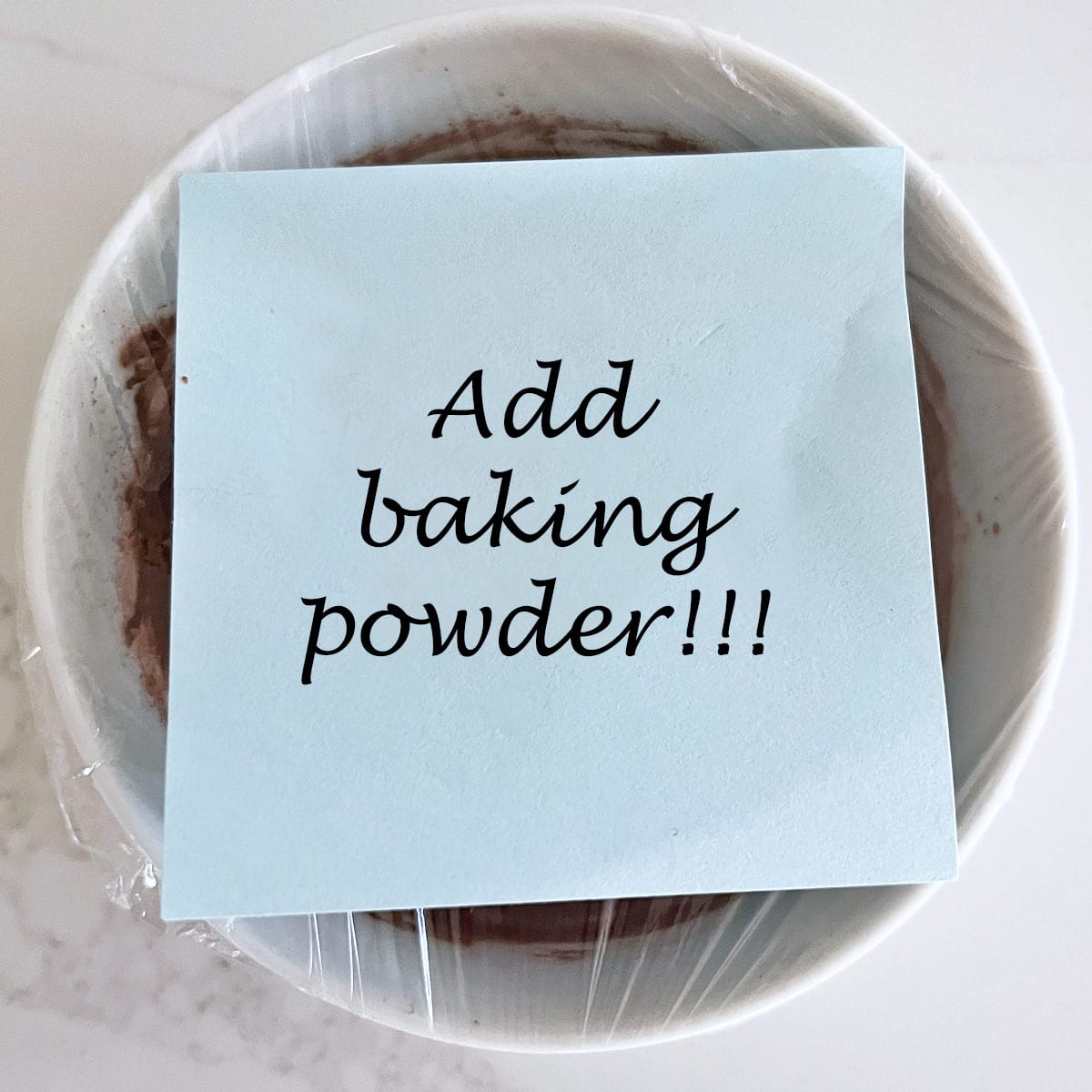 A reminder on a premade chocolate mug cake to add baking powder.