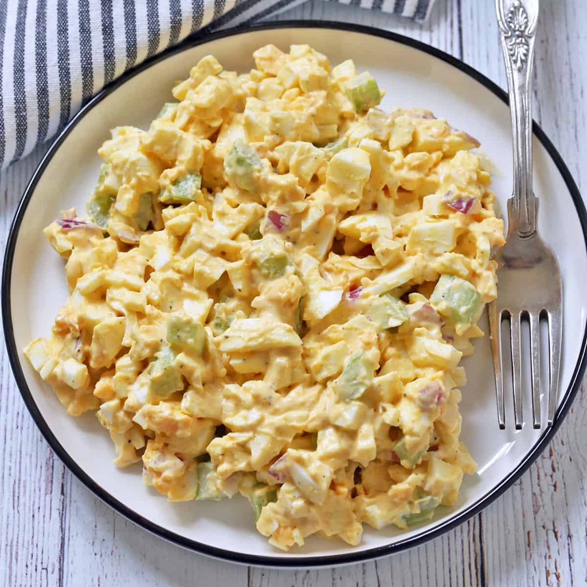 Egg salad is served on a plate with a fork.