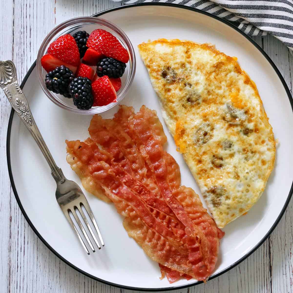 An egg white omelette is served with bacon and berries.