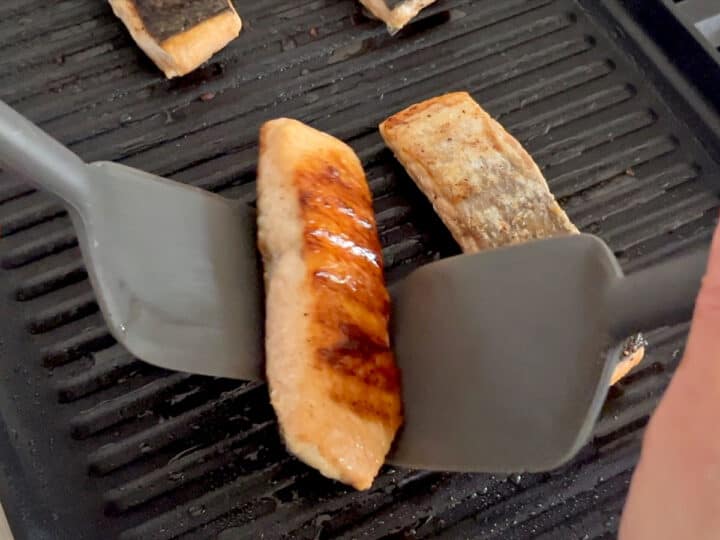 Flipping the salmon on the grill.