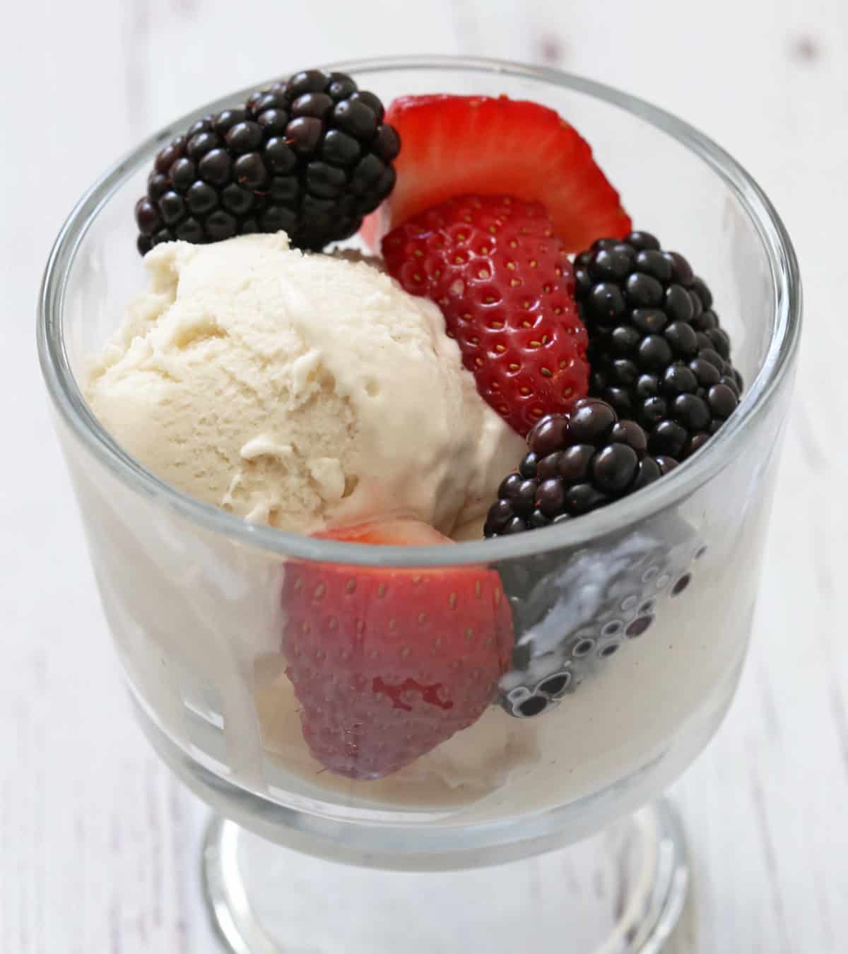 Frozen yogurt is served with berries.