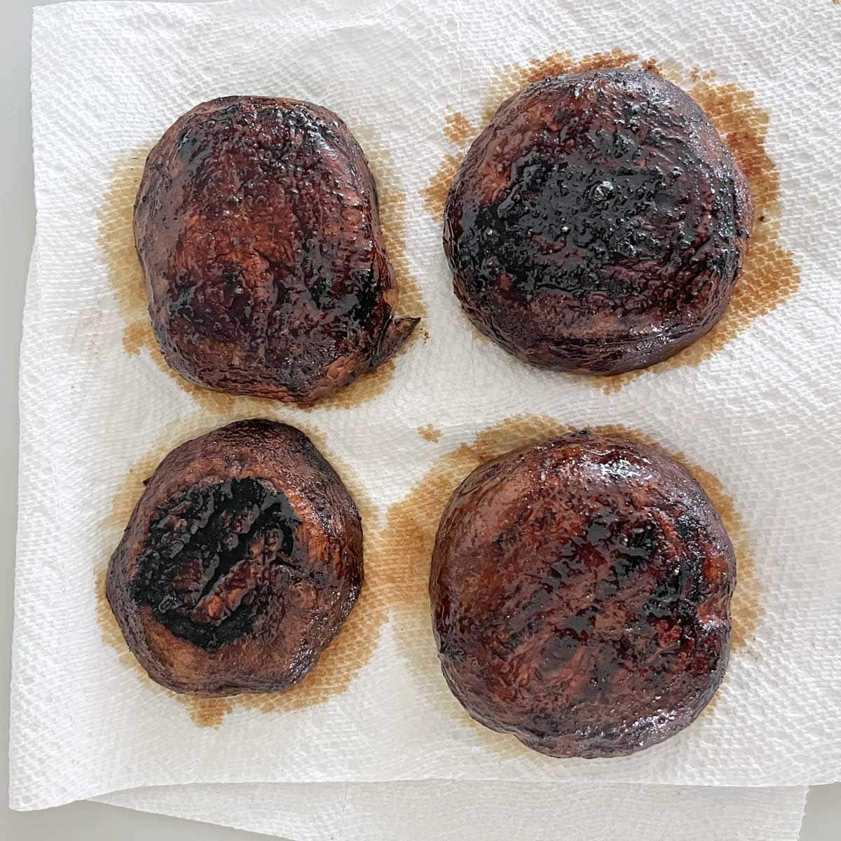Placing the grilled mushrooms on paper towels.