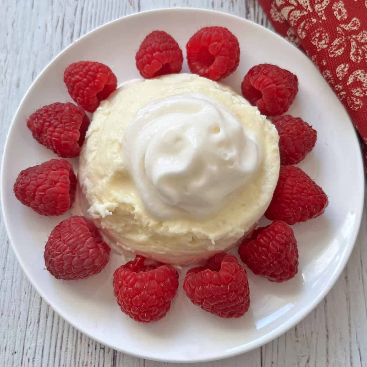 Microwave cheesecake is served with whipped cream and berries.