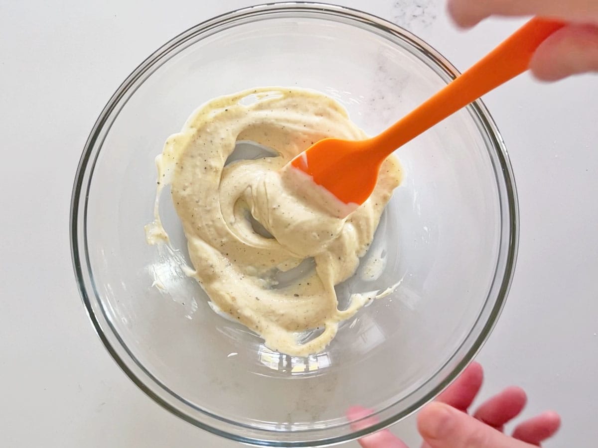 Mixing the dressing in a bowl.