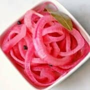 Pickled red onions are served in a bowl.