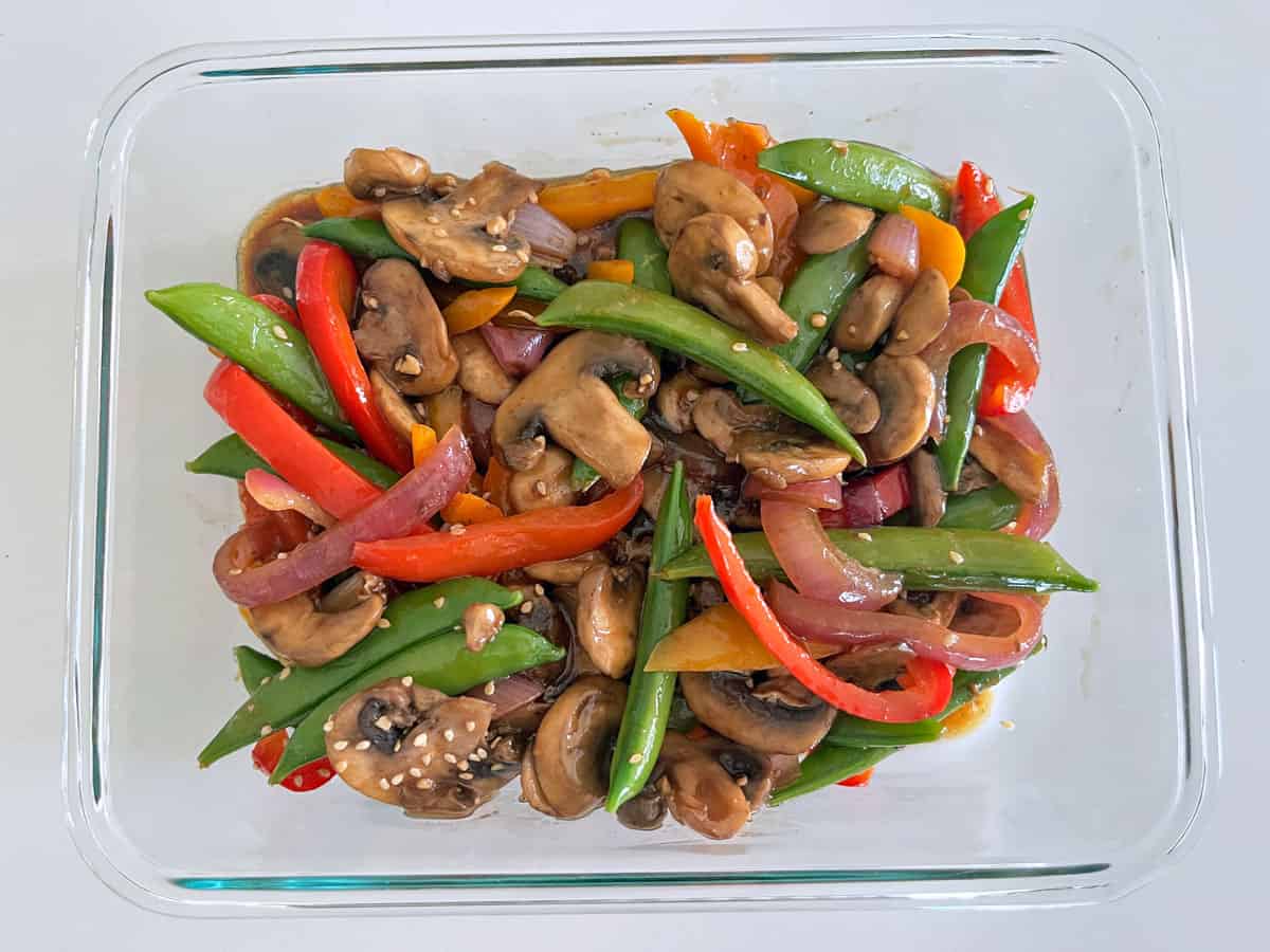 Vegetable stir-fry is kept in a glass food storage container.