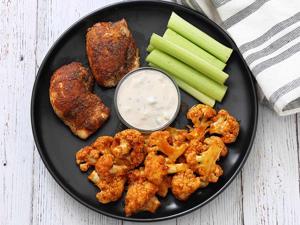 Buffalo cauliflower is served with Cajun chicken.