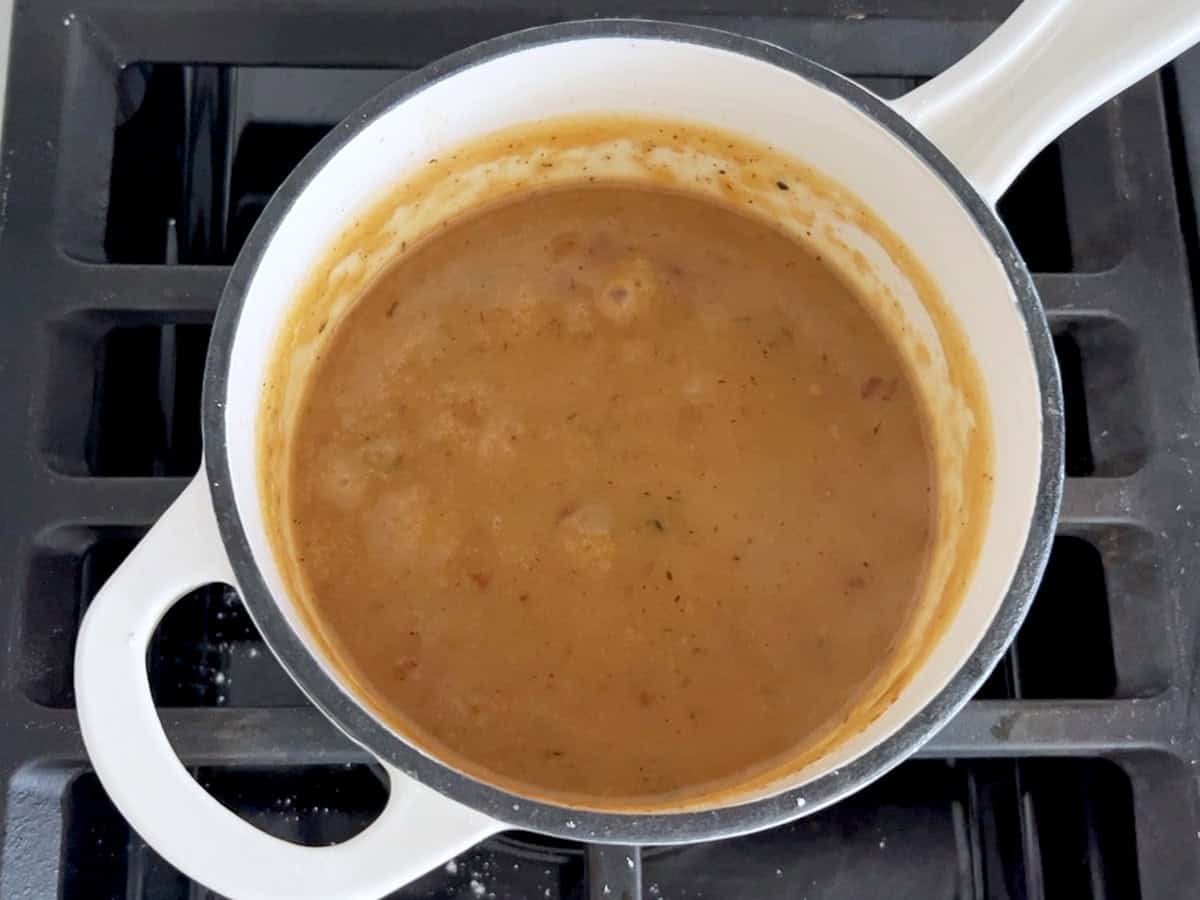 Thickened gravy in a saucepan.