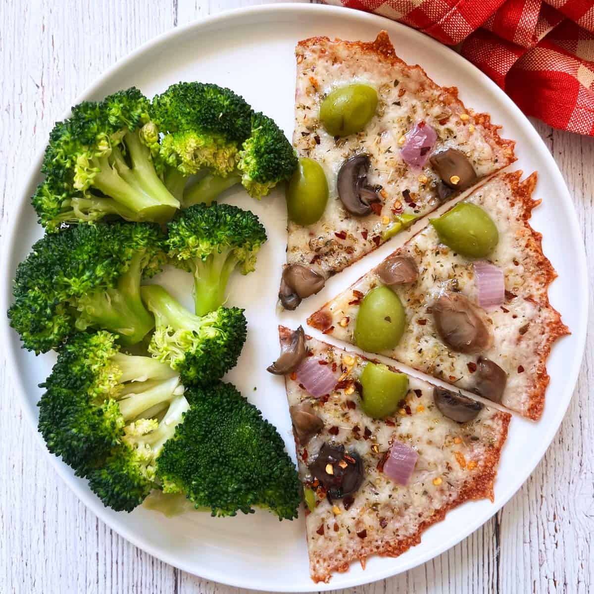 Crustless pizza is served with steamed broccoli.