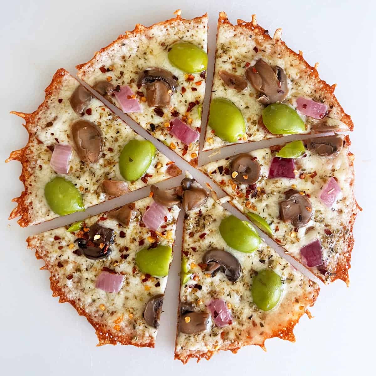 A crustless pizza variation with red onions, mushrooms, and olives.