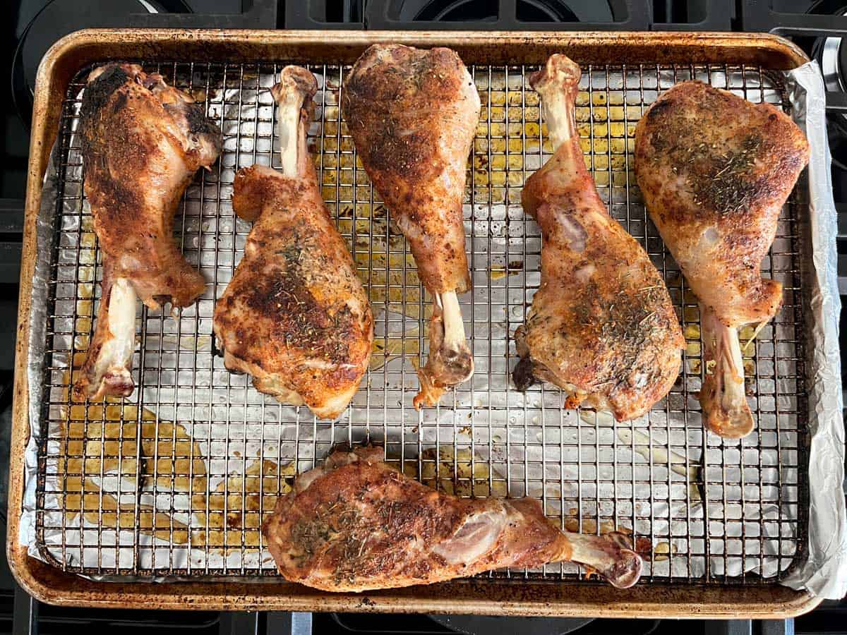 Roasted turkey legs on a baking sheet.