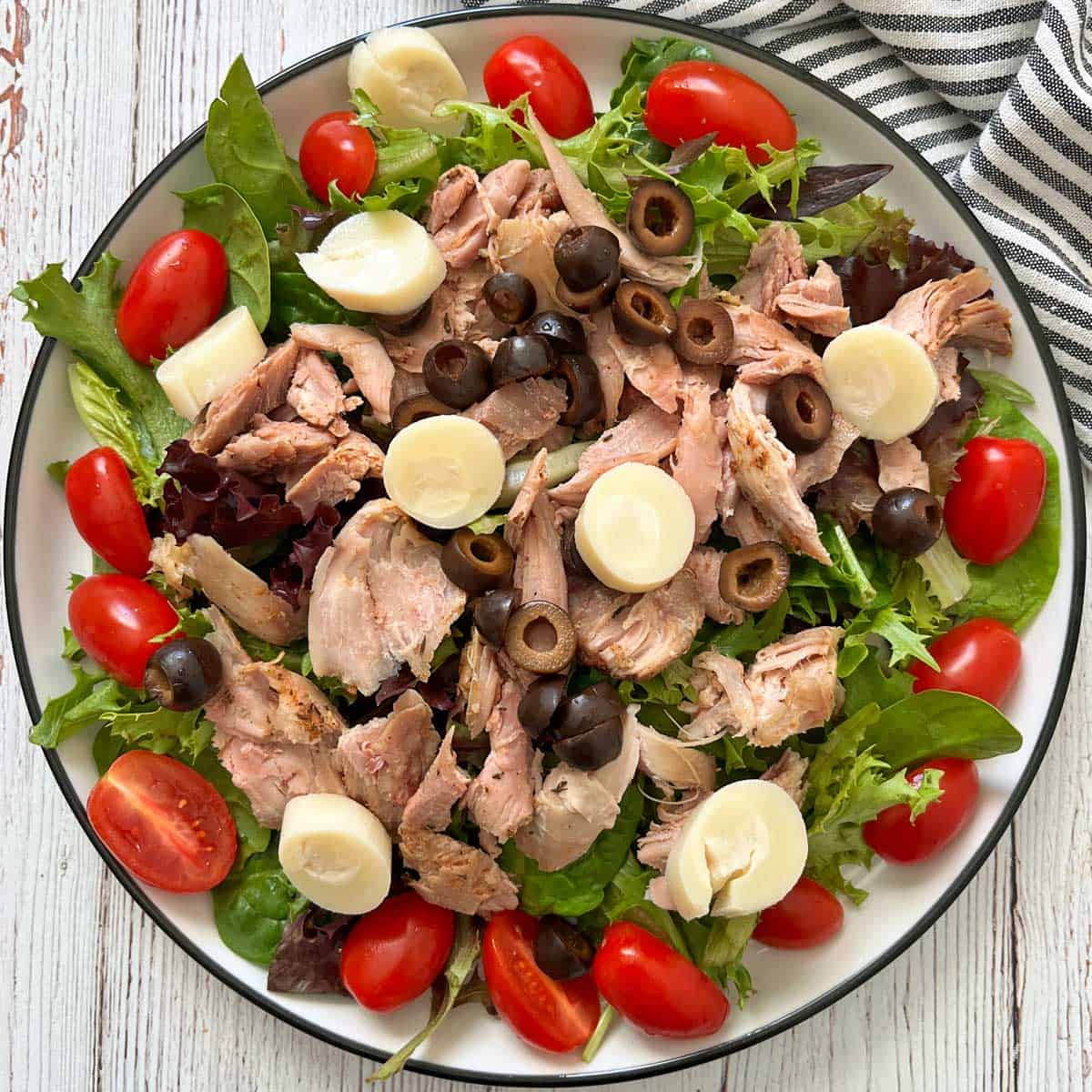 A salad made with leftover turkey, lettuce, tomatoes, olives, and hearts of palm slices.