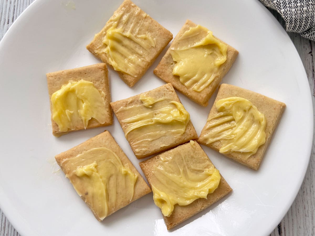 Almond flour crackers are topped with butter.