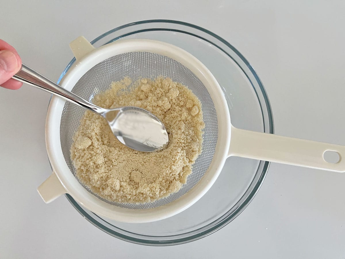 Sifting almond flour.
