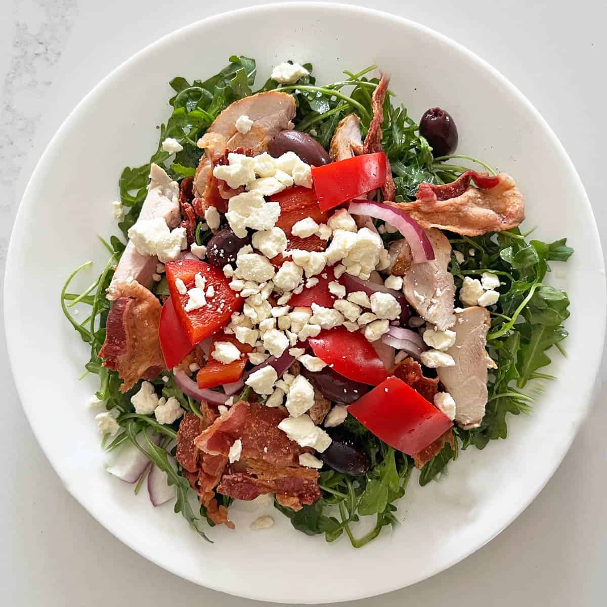 Arugula salad is topped with goat cheese.