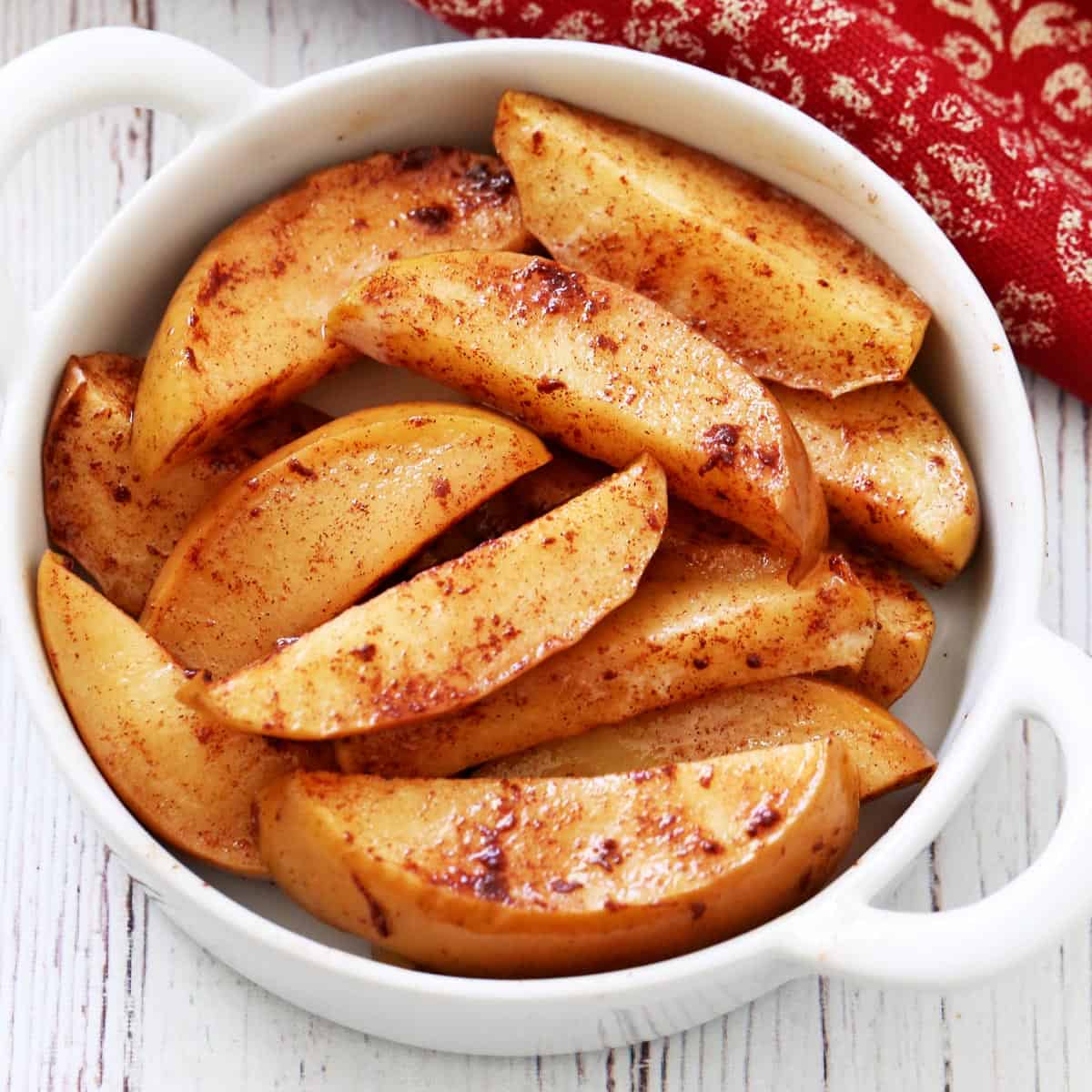 Baked apple slices in a white bowl.