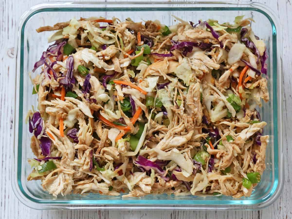 Chinese chicken salad leftovers are stored in a glass container.