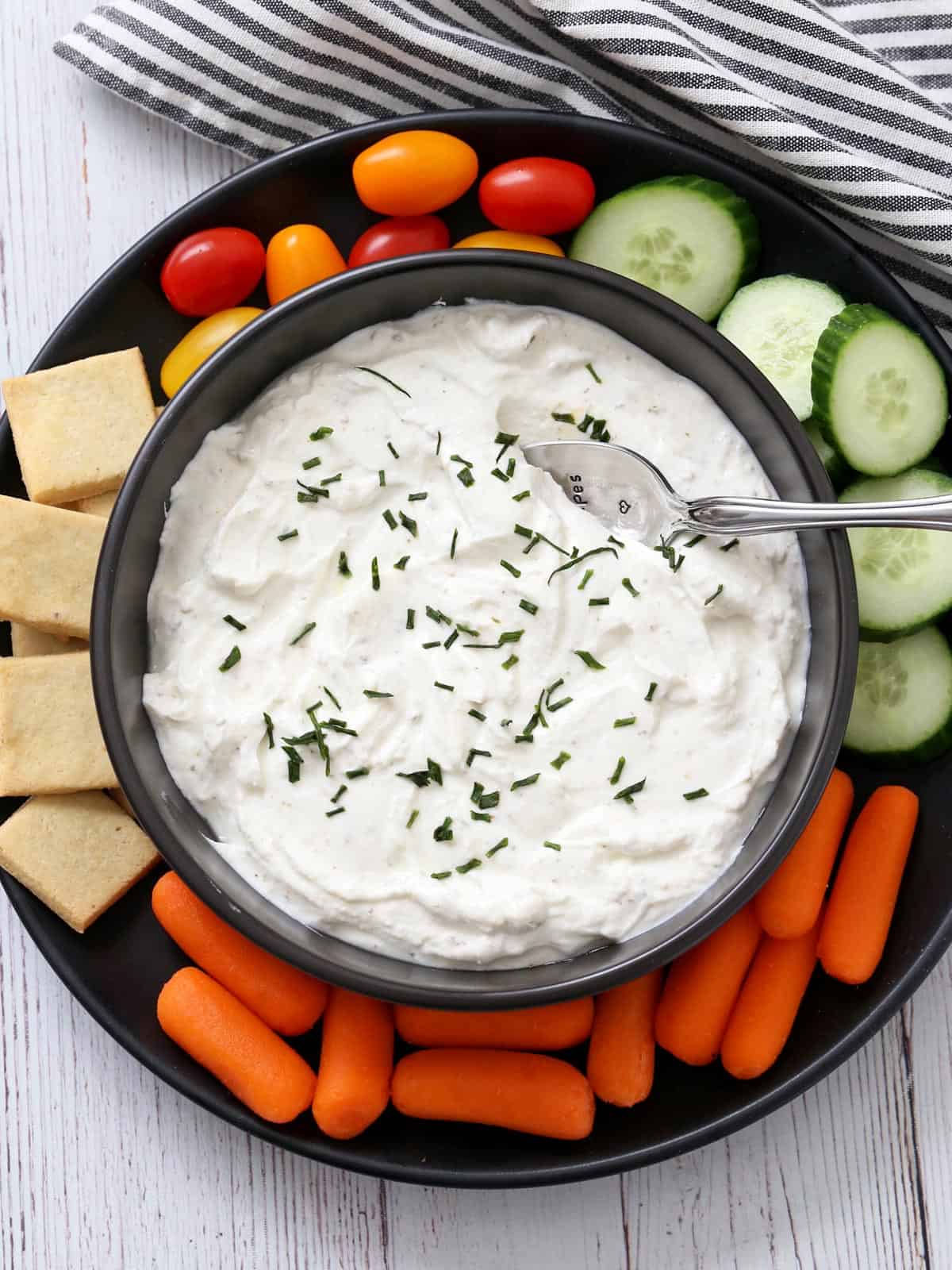Greek yogurt dip is served with crackers and veggies.