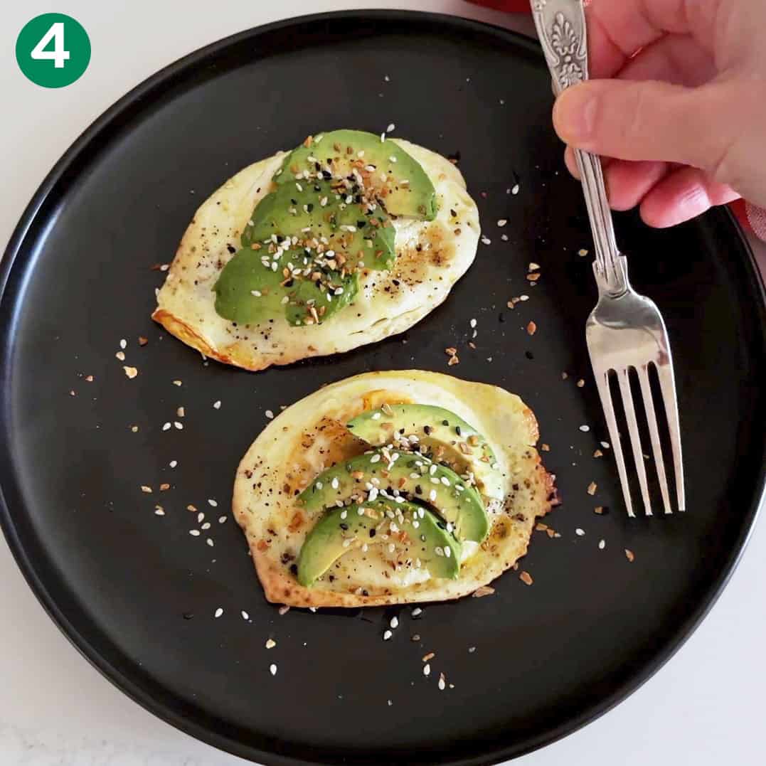 Serving the eggs, topped with avocado.