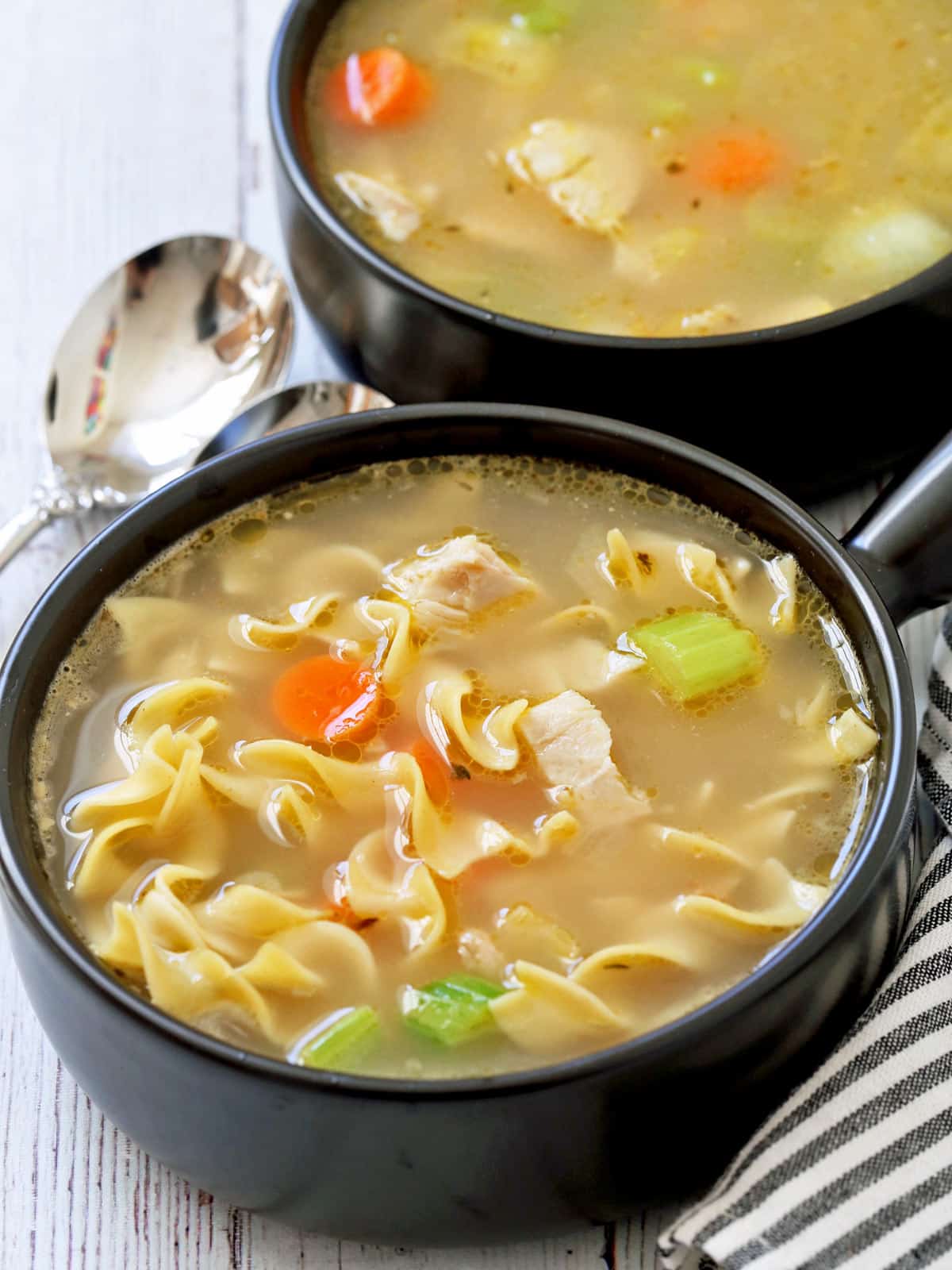 Two dark bowls with leftover turkey soup.