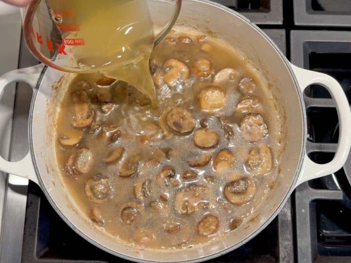 Adding chicken broth to the pot.
