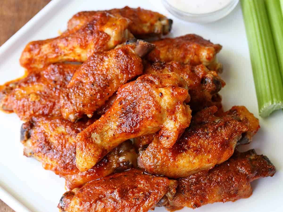 Buffalo chicken wings are served with celery.