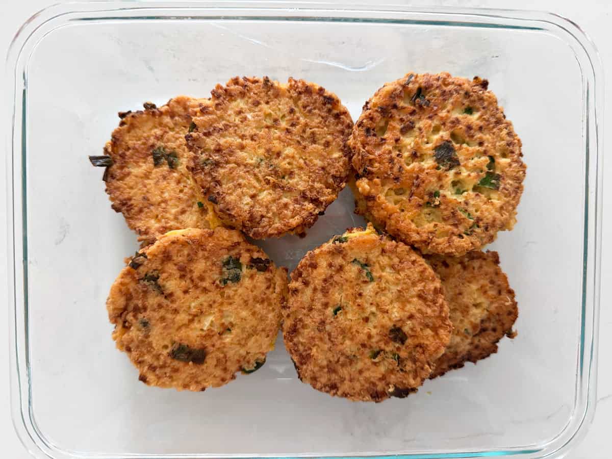 Cauliflower fritters are stored in a glass container.