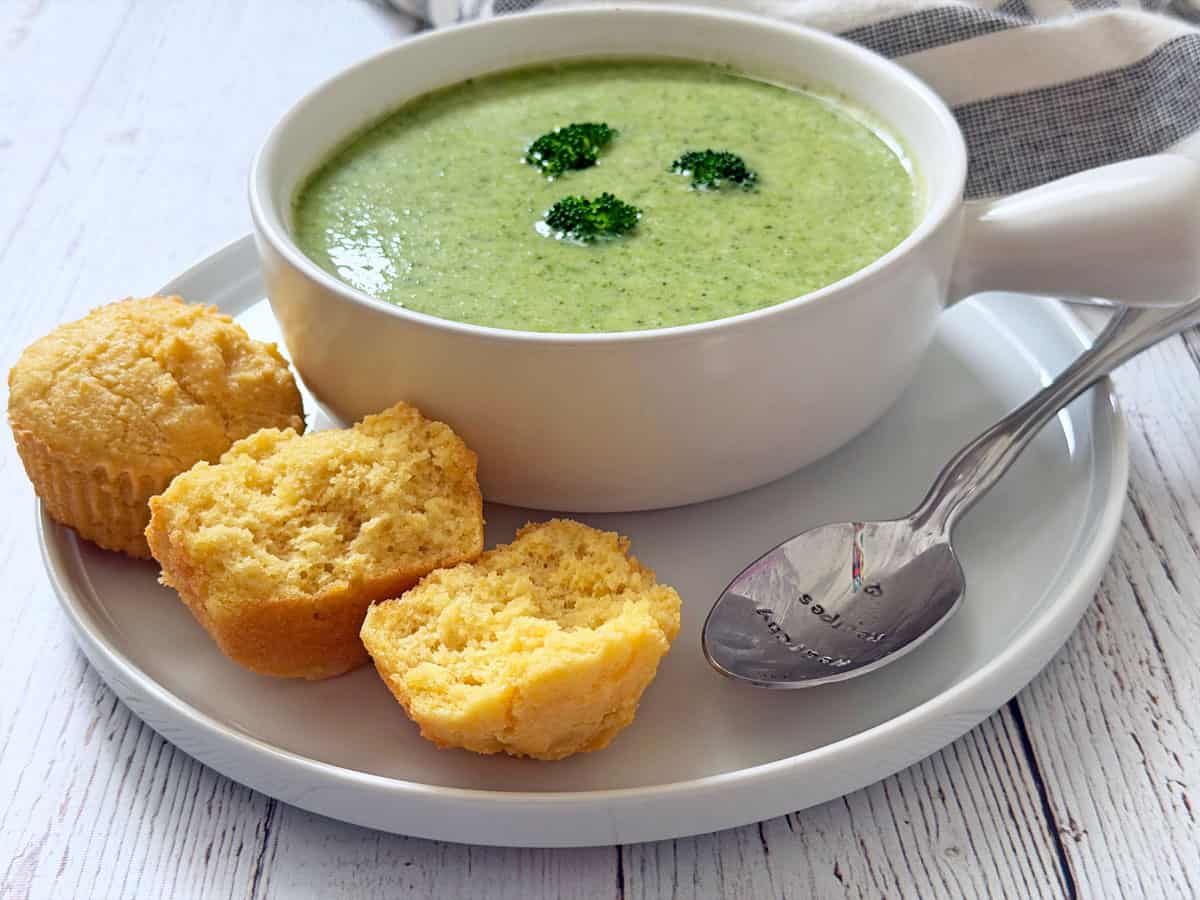 Keto cornbread muffins are served with broccoli soup.