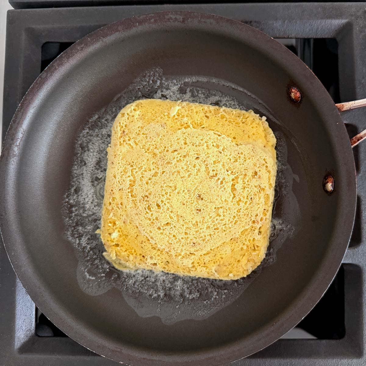 Toasting the bread in butter.