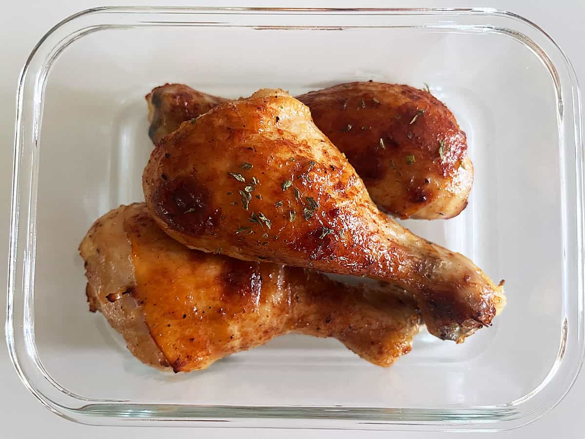Honey garlic chicken leftovers are stored in a glass container.