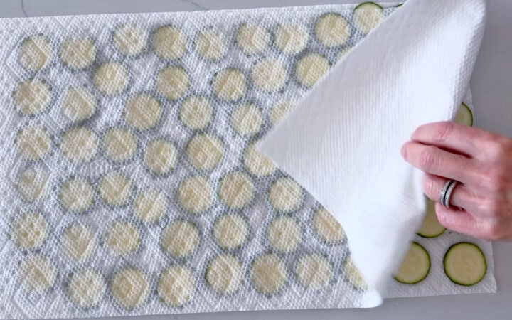 Blotting the zucchini dry.